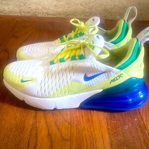 White Nike Air270 tennis shoes with blue sole and yellow highlights.